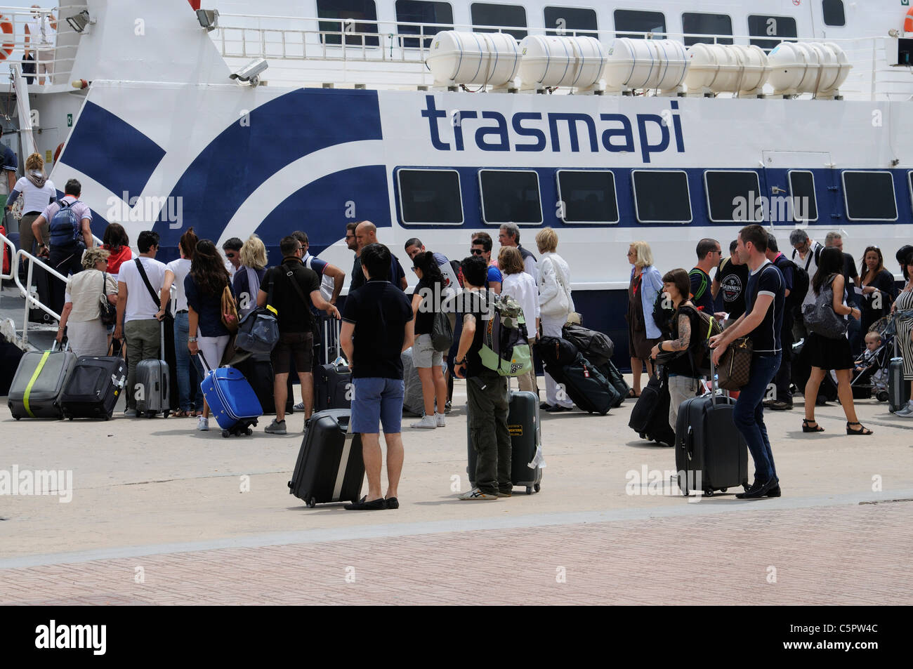 Holiday makers with luggage on wheels boarding a ferry at Eivissa Ibiza bound for Formentera another Spanish island in the Med Stock Photo