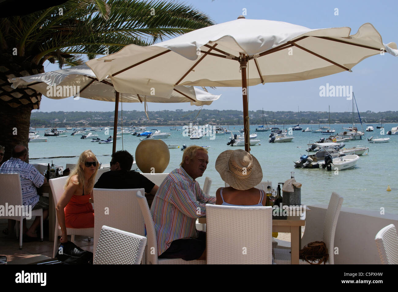 Customers dining in a waterfront restaurant on the Spanish island of Formentera Stock Photo