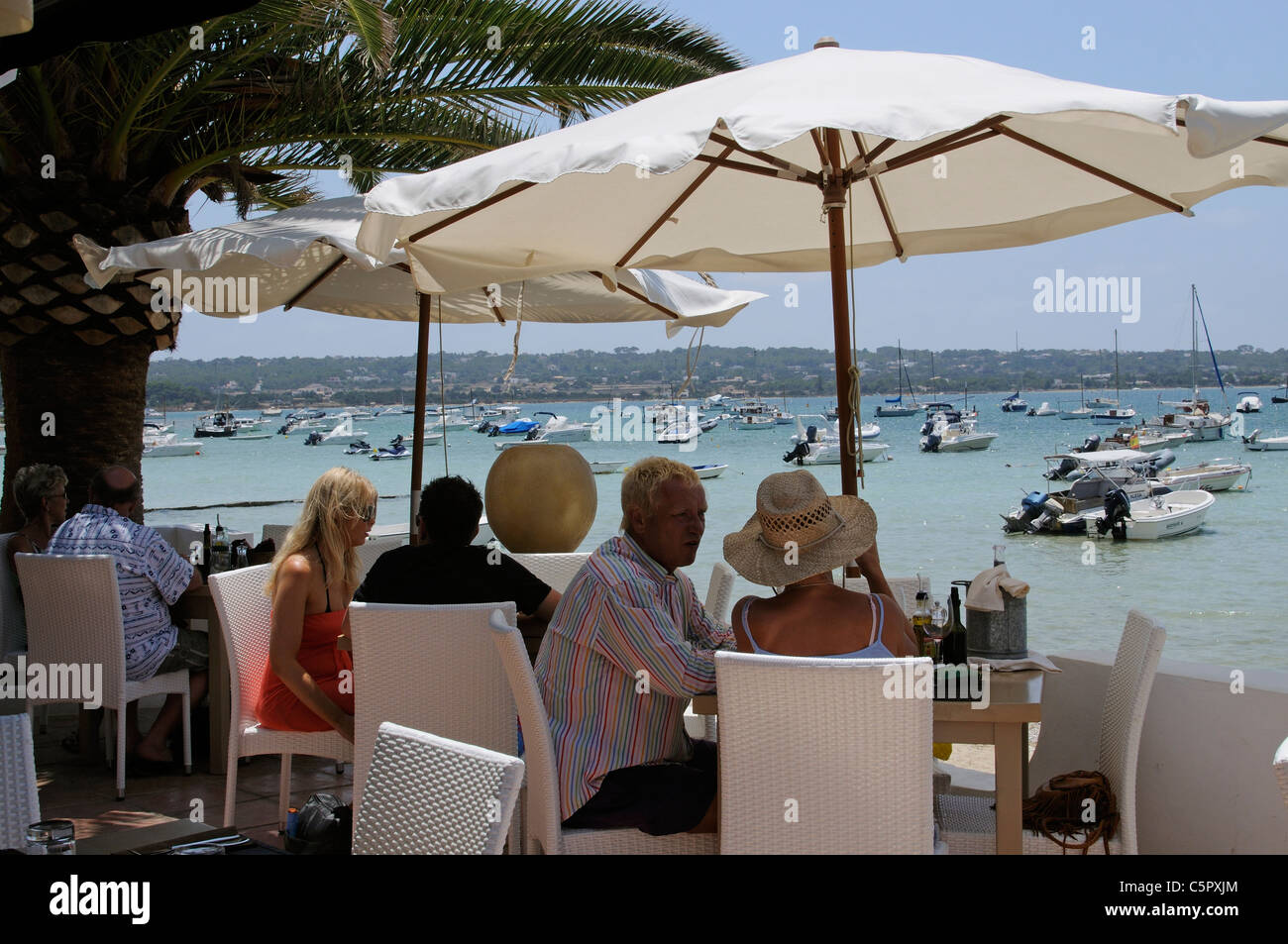 Customers dining in a waterfront restaurant on the Spanish island of Formentera Stock Photo
