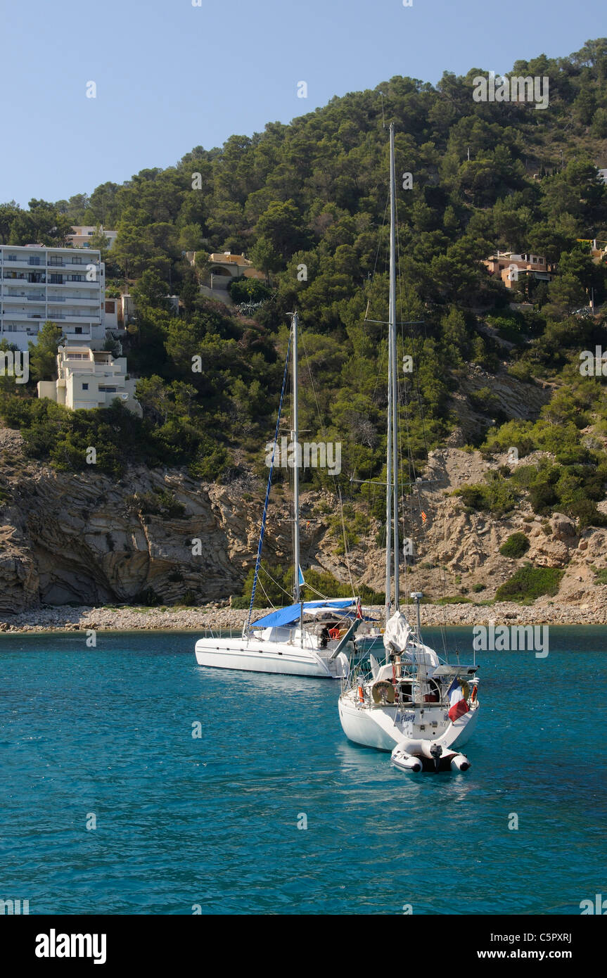 Boats moored in the inlet of Spanish seaside resort of Cala Llonga on Ibiza island Stock Photo