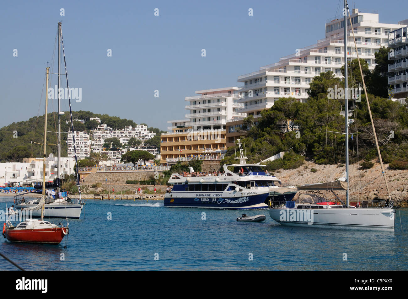 Boats moored in the inlet of Spanish seaside resort of Cala Llonga on Ibiza island Stock Photo