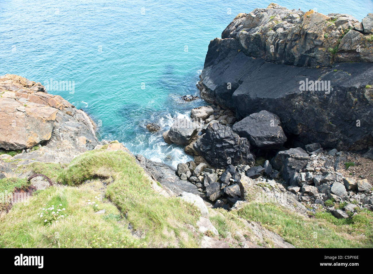 Rocks meet the lashing waves of the sea at the coast in St Ives, Cornwall. Stock Photo