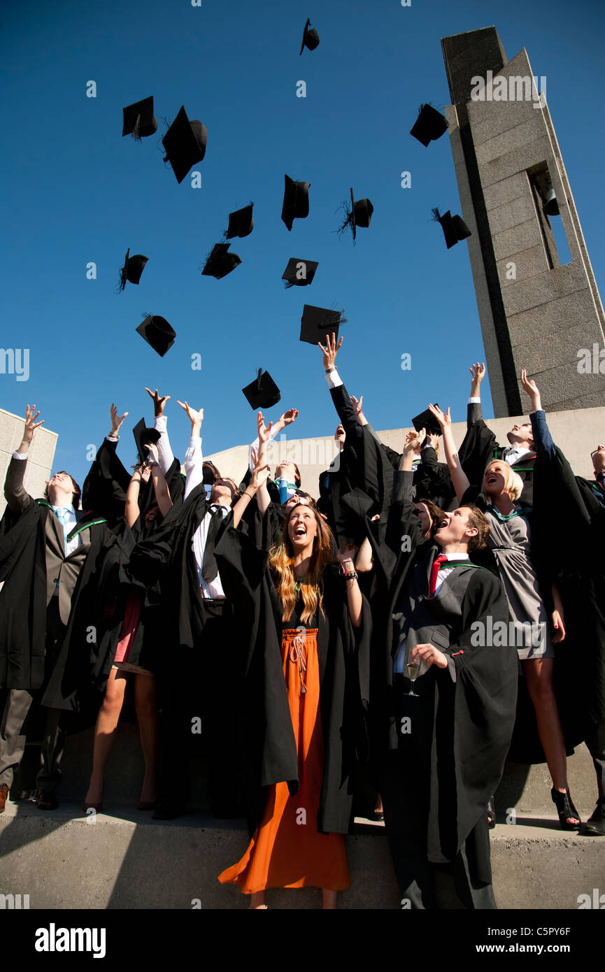 A group of Aberystwyth university students graduating on graduation day, throwing their caps in the air, UK Stock Photo