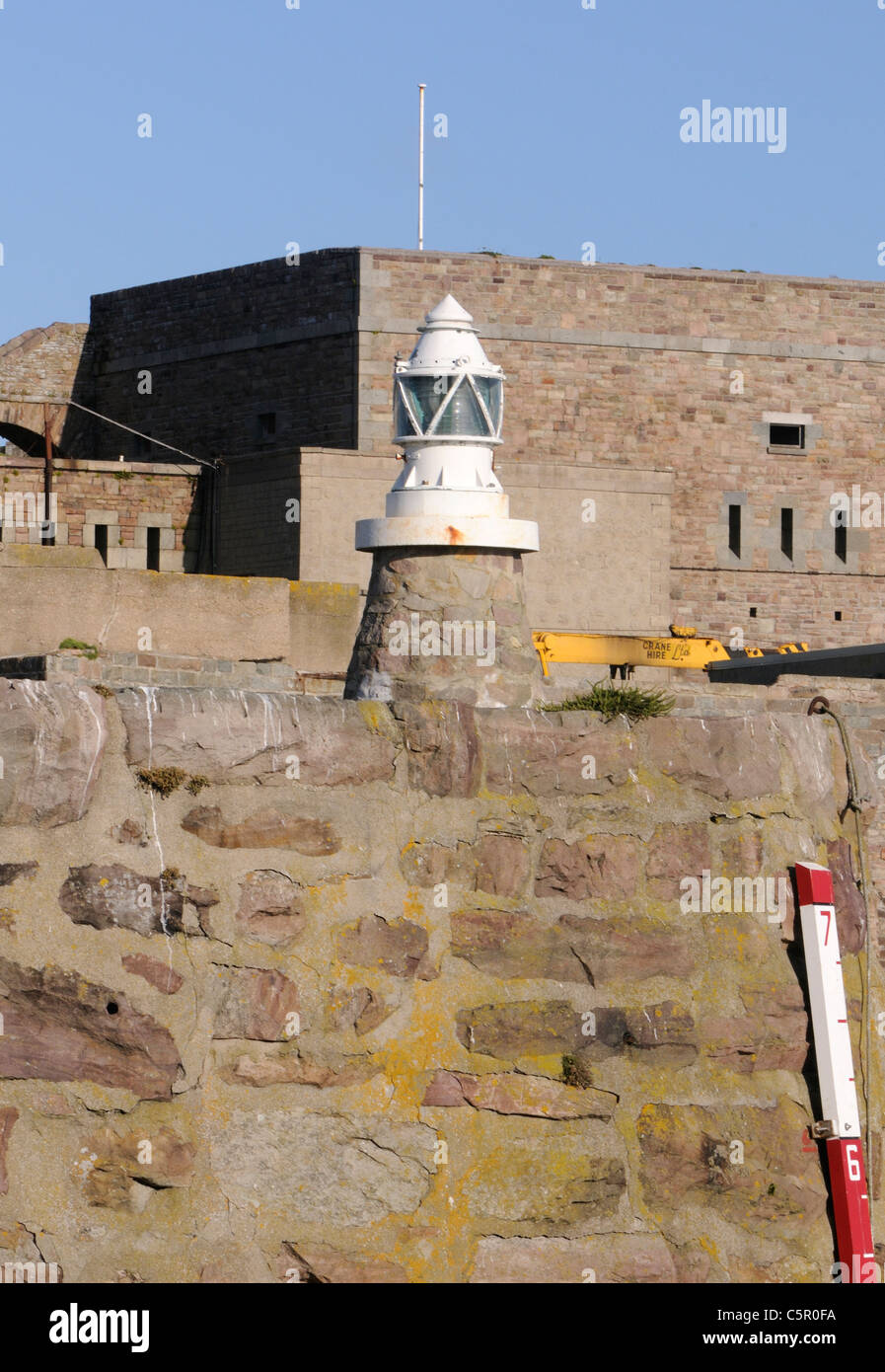 Navigation light on the wall of  Braye Harbour.  Alderney, Channel Islands, UK. Stock Photo