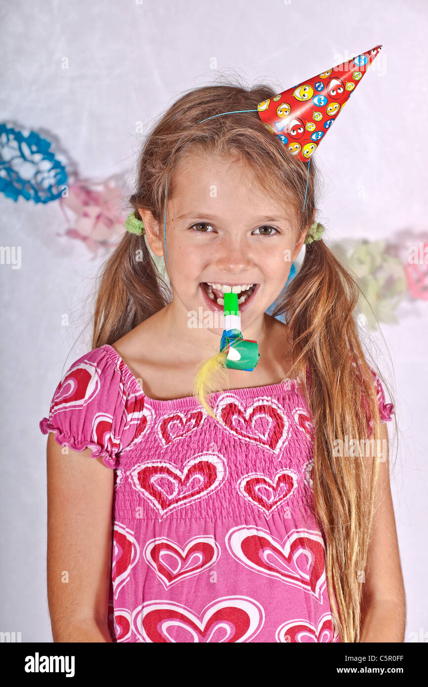 eight year old girl with party hat and trumpet on a children's festival