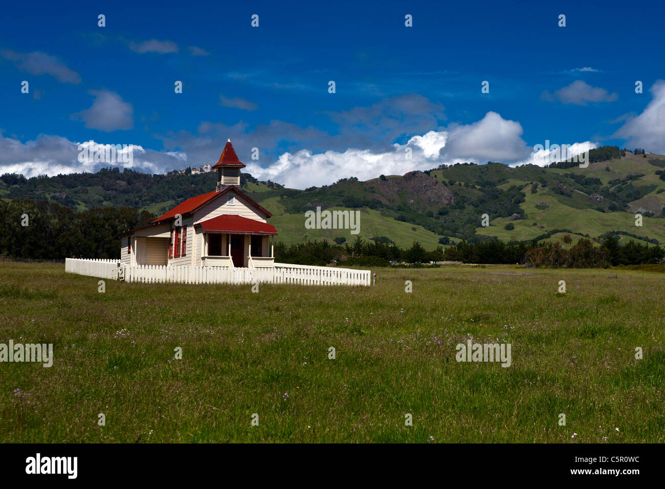 One room school house with Hearst Castle in the background, San Simeon, California, United States of America Stock Photo
