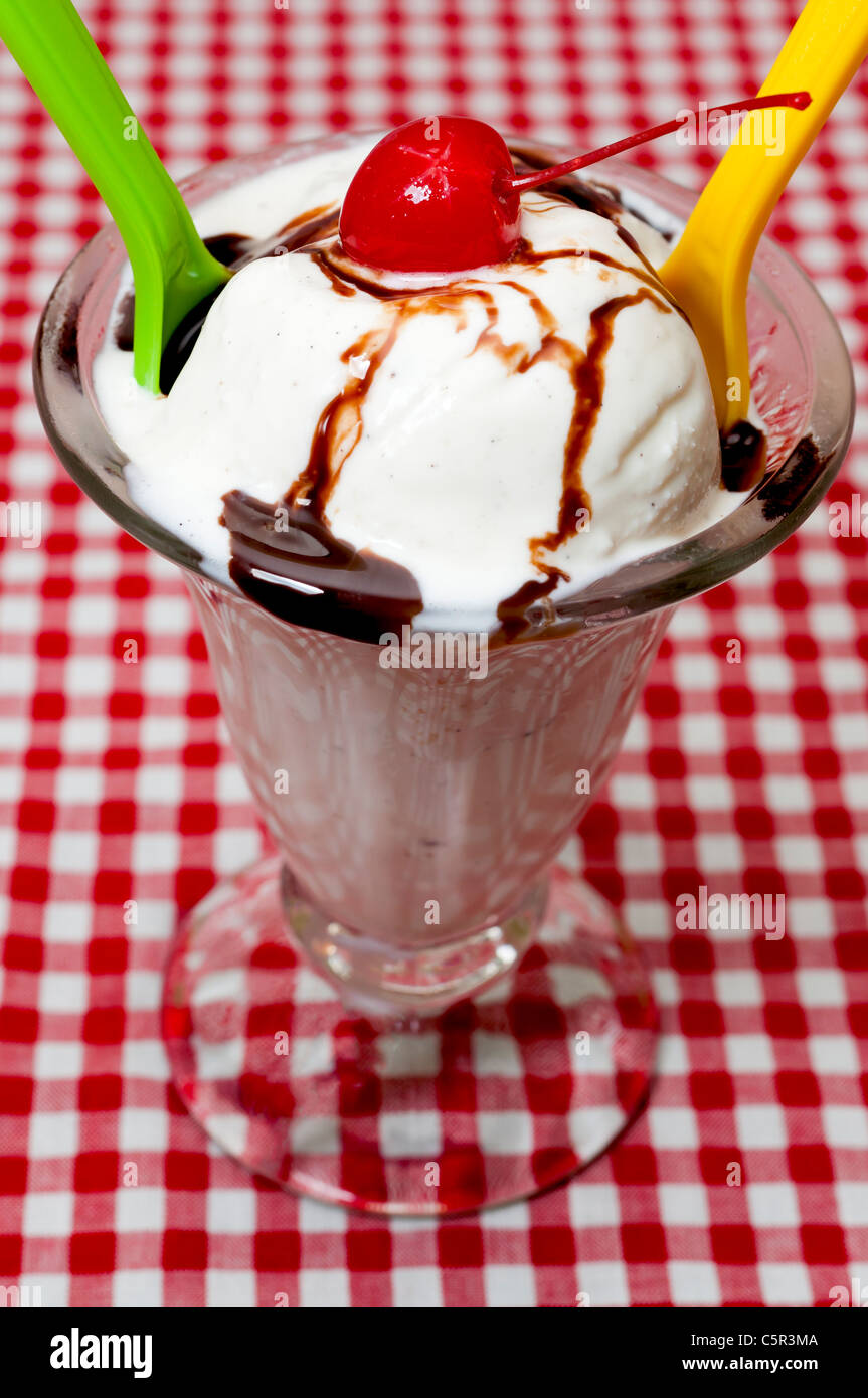 Vanilla Ice Cream and Spoons with Cherry and Chocolate Topping Stock Photo
