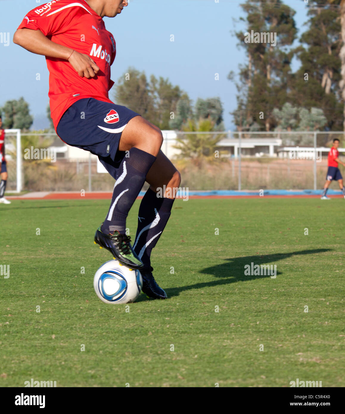 Soccer player dribbling the ball on the field Stock Photo