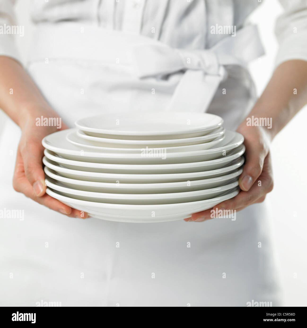 A person holding pile of dishes Stock Photo
