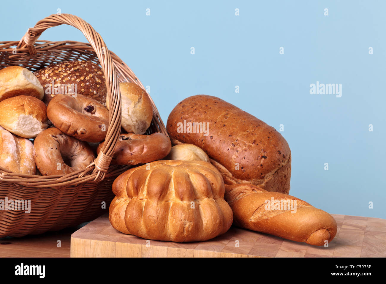 Photo of different types of bread spilling out from a basket. Stock Photo