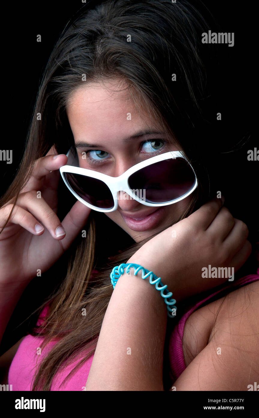 Beautiful young girl posing against a black background Stock Photo - Alamy