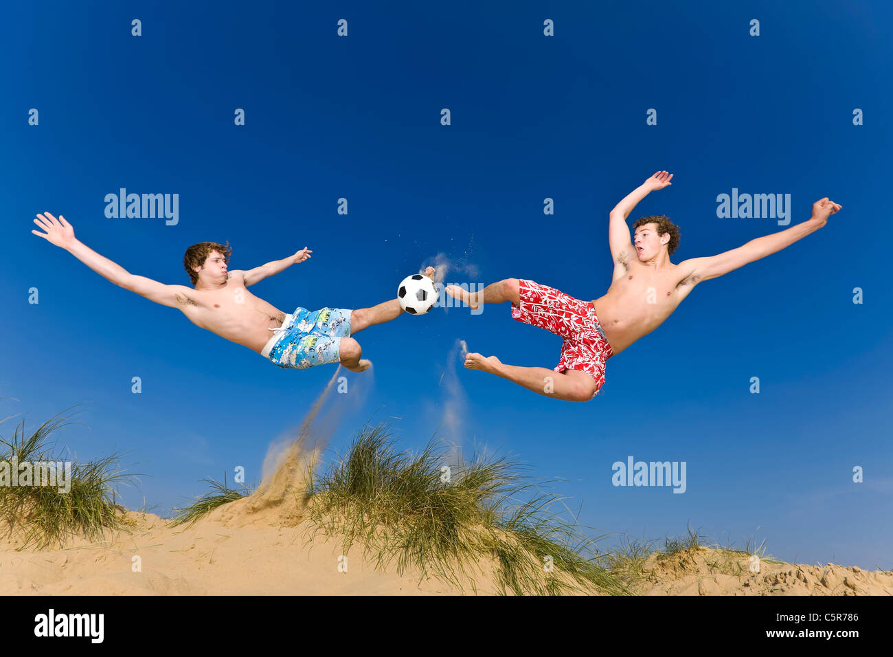 Two soccer players compete in mid air to volley the ball Stock Photo Alamy