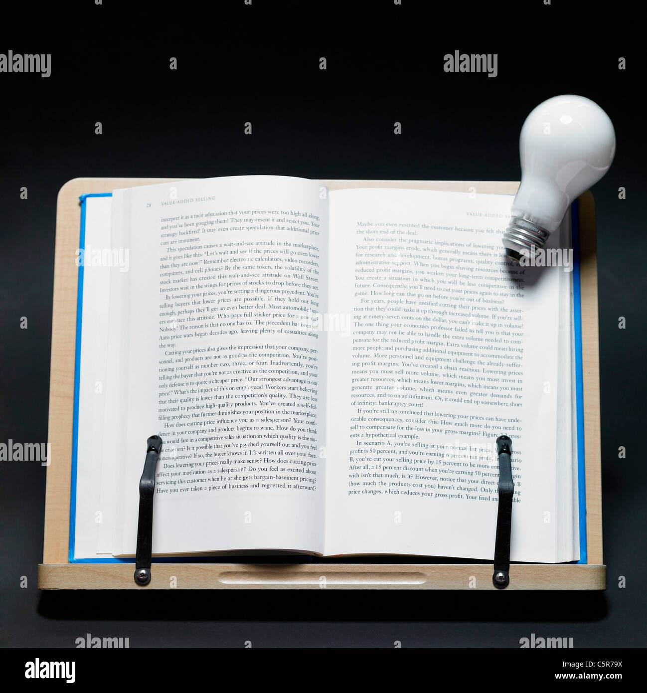 A book on a book holder and a light bulb Stock Photo Alamy
