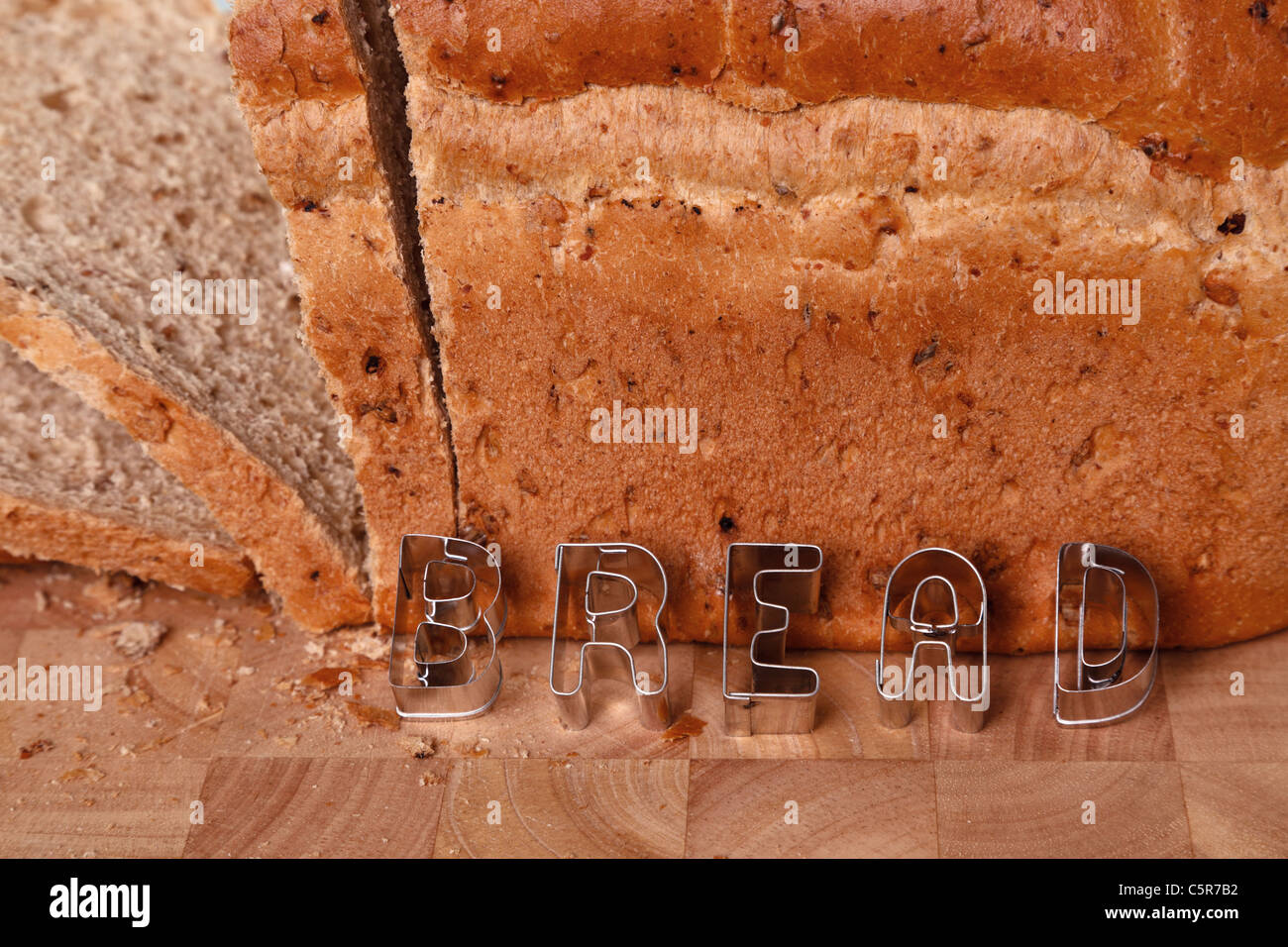 Photo of a loaf of brown bread with the word in in pastry letters. Stock Photo