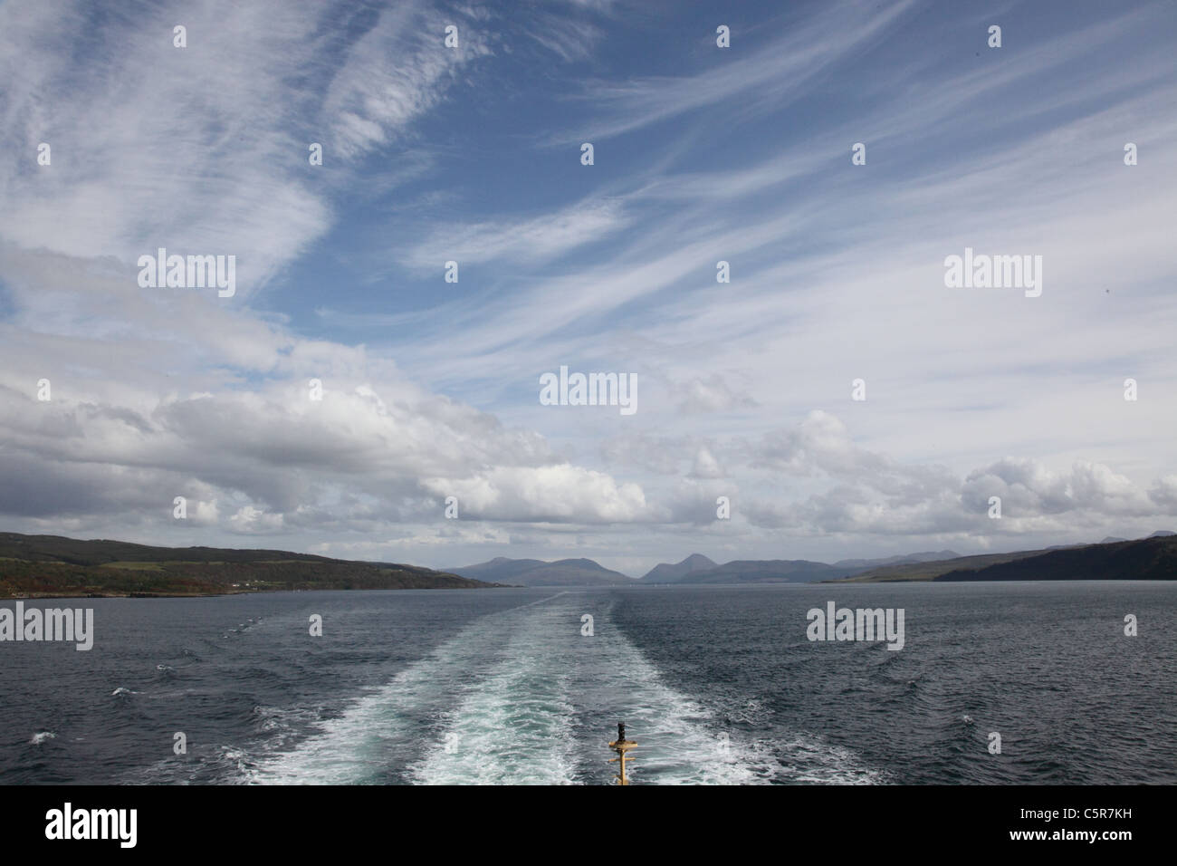 Sea scape showing clouds seen against a blue sky, with wake of ship in foreground. Photo taken  from Hebridean Ferry Stock Photo