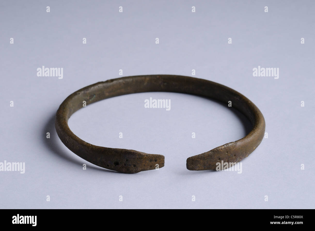 Bronze bracelet , represented in the end of two snakes heads facing and dotted decoration . Roman period in Complutum . SPAIN Stock Photo