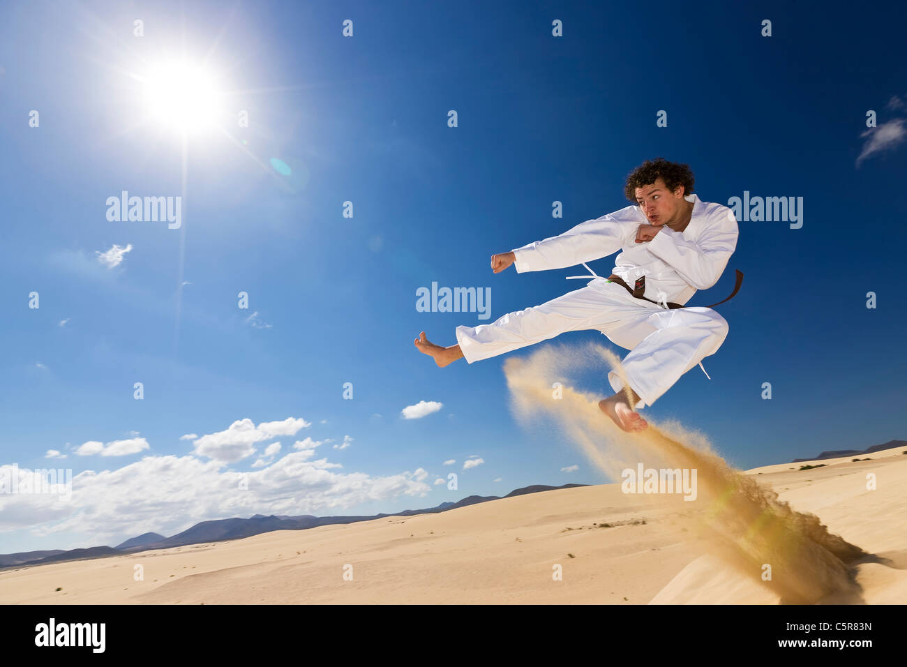 Martial artist training on dunes. Stock Photo