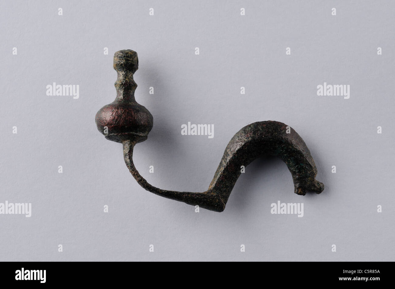 Bronze fibula , back foot type without needle. Roman period in Complutum . SPAIN Stock Photo