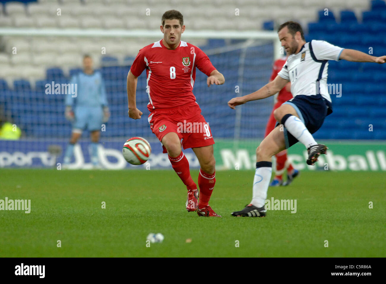 Wales and Scotland at the new Cardiff City Stadium : Wales' Ched Evans is caught by Scotlands  James McFadden. Stock Photo