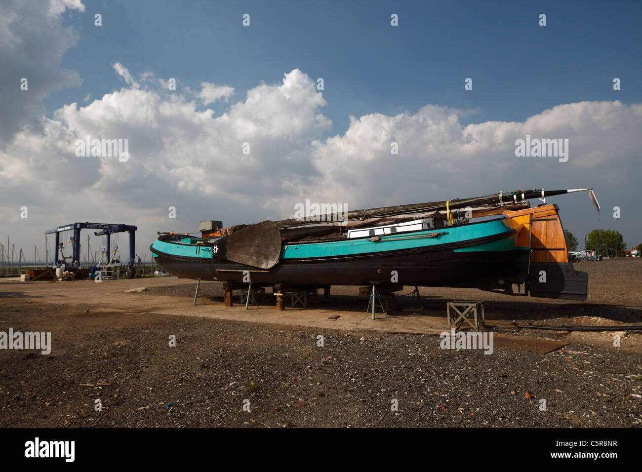 An old Thames barge in dry dock, showing it s very flat bottom hull shape. Stock Photo