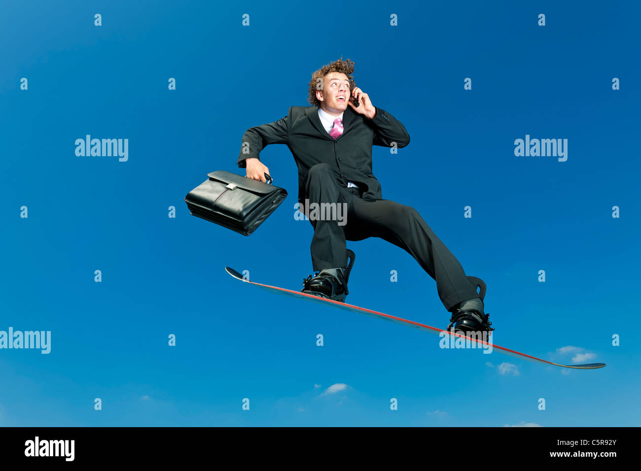 A businessman snowboarder on cell phone. Stock Photo