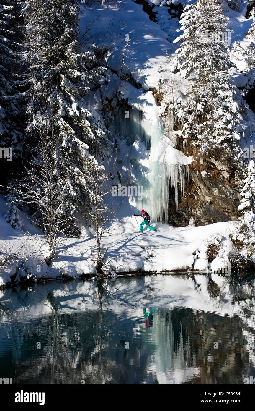 Snowshoeing around a stunning winter Alpine mountain lake Stock Photo