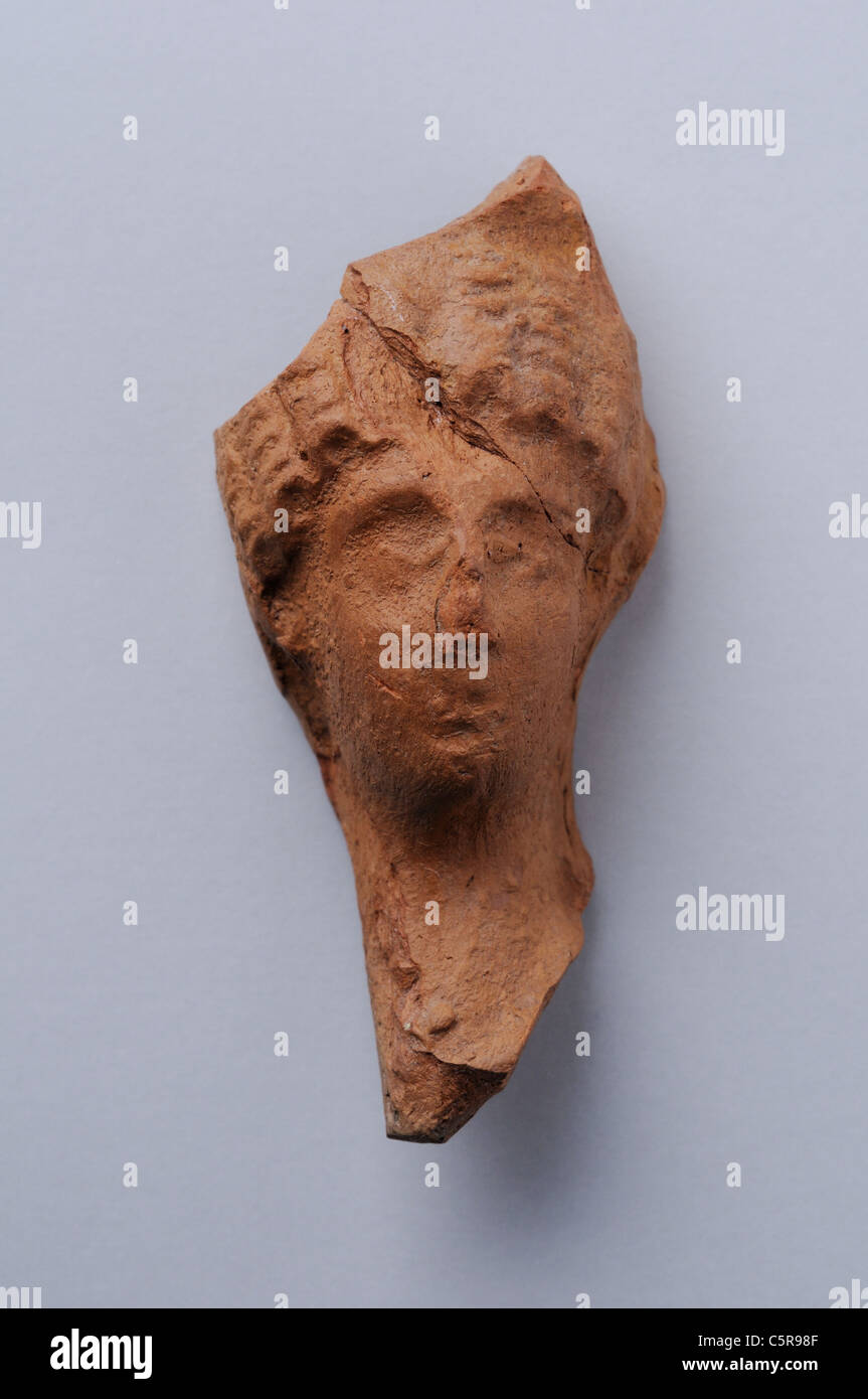 Head female terracotta figurine loops Roman hairstyle. Height 6, 7 cm Width 3, 1 cm. Roman period in Complutum . SPAIN Stock Photo