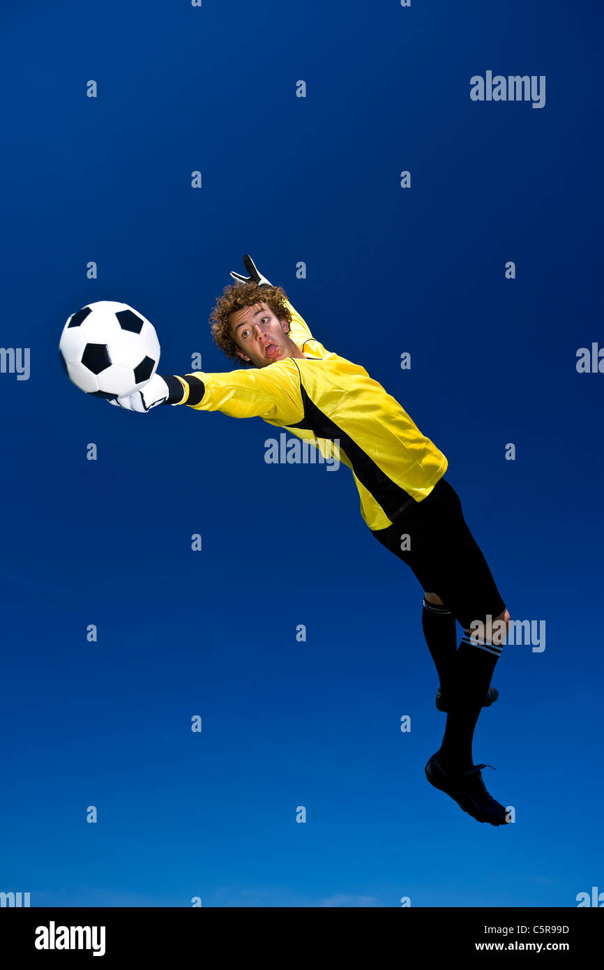 A goalkeeper stretches to make a save. Stock Photo