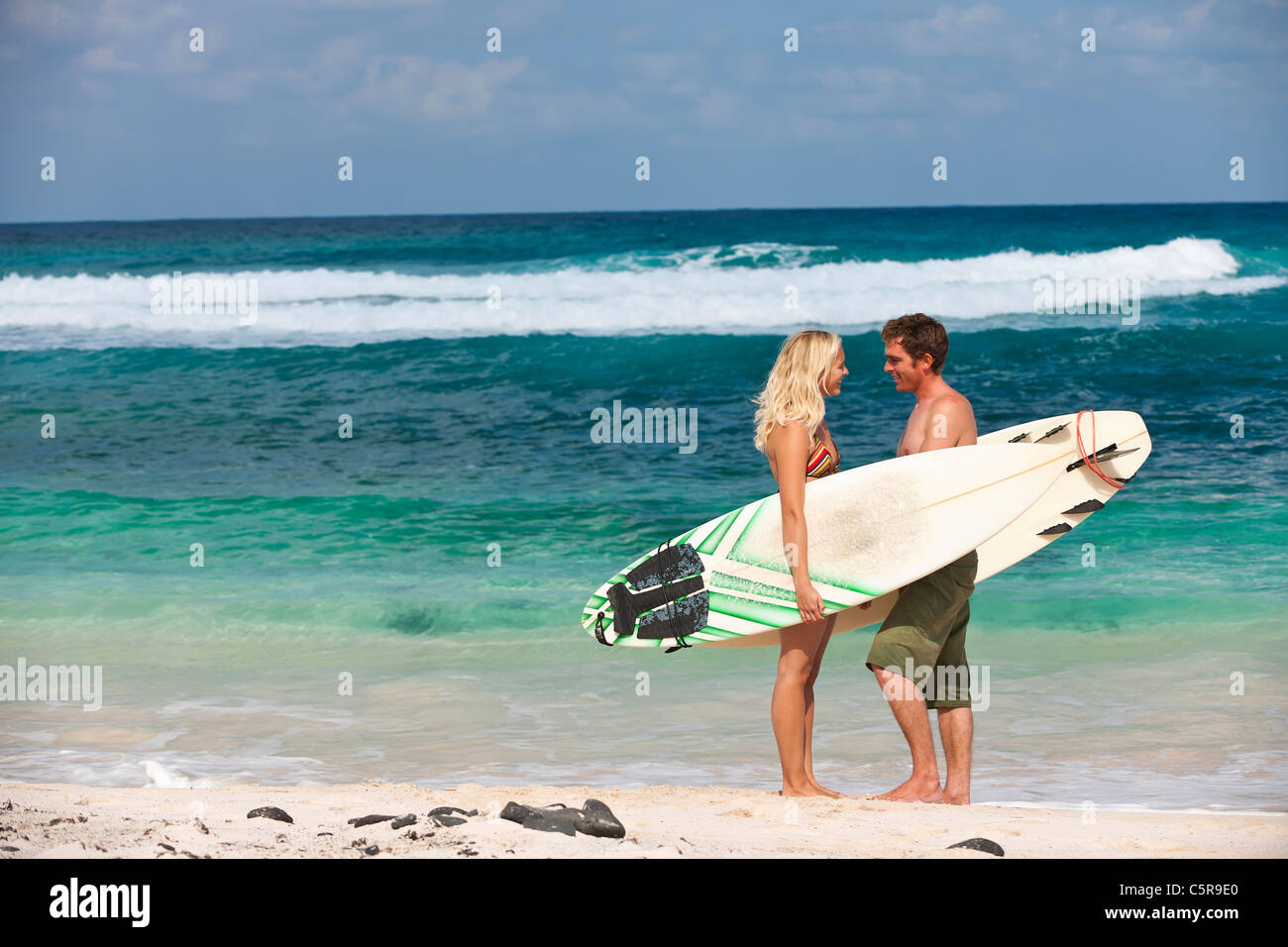 A surfing couple on beach. Stock Photo