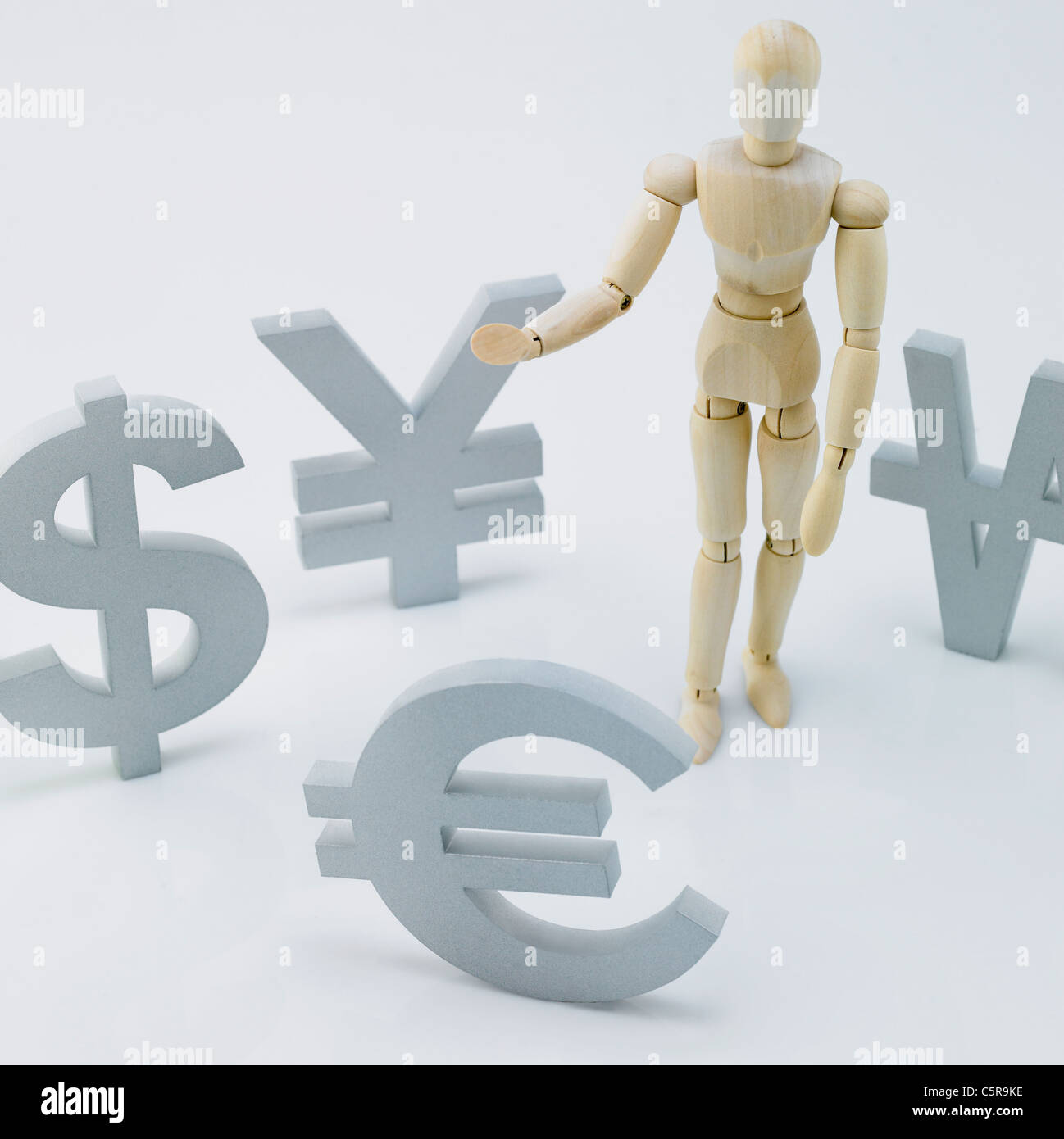 A wooden figurine and currency sign around the world Stock Photo