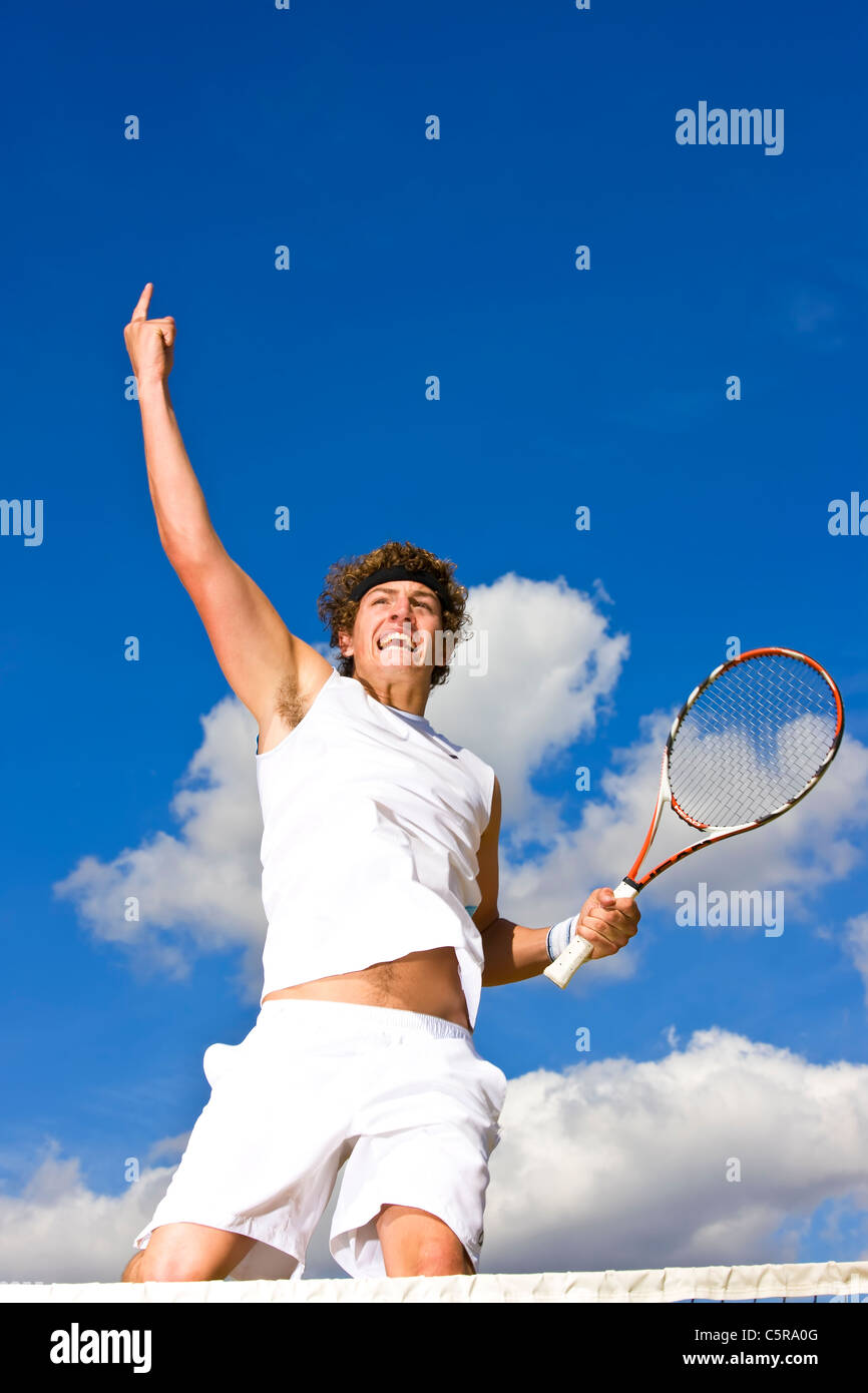 A tennis player jumps into the air and celebrates. Stock Photo