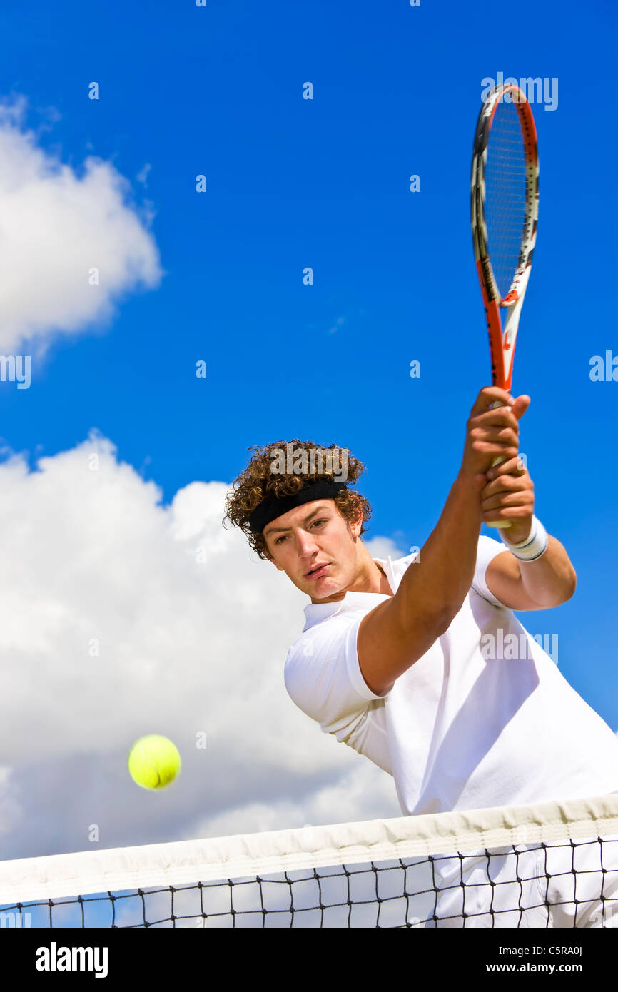 Tennis player returns the ball over net Stock Photo Alamy