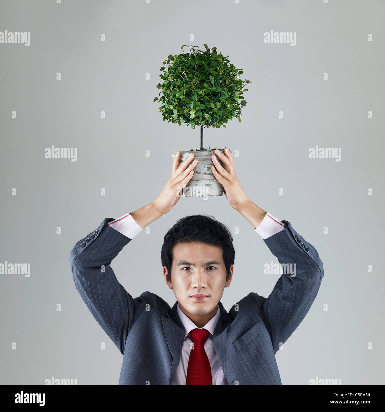 A man holding a flower pot up on his head Stock Photo - Alamy