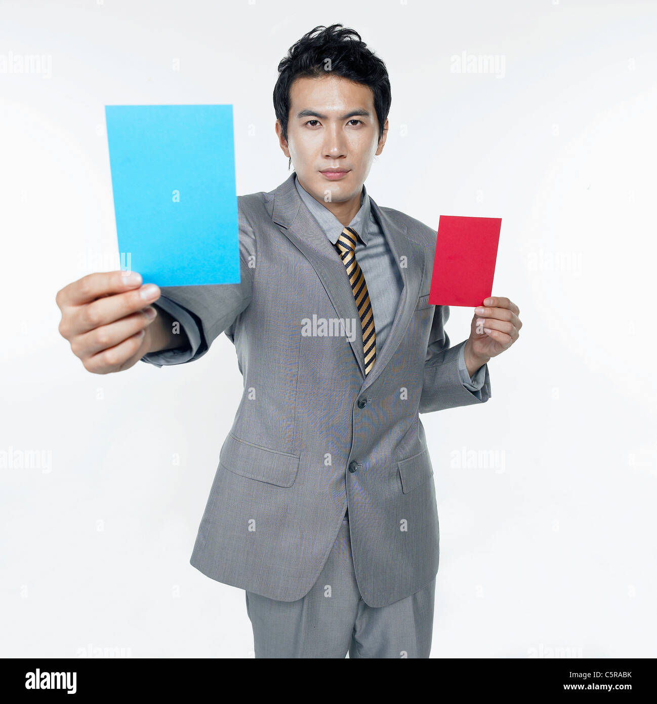 A man holding a red card and a blue card Stock Photo