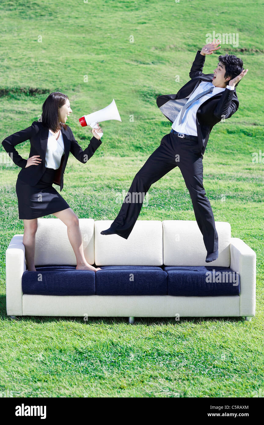 A woman speaking with loudspeaker to a man Stock Photo