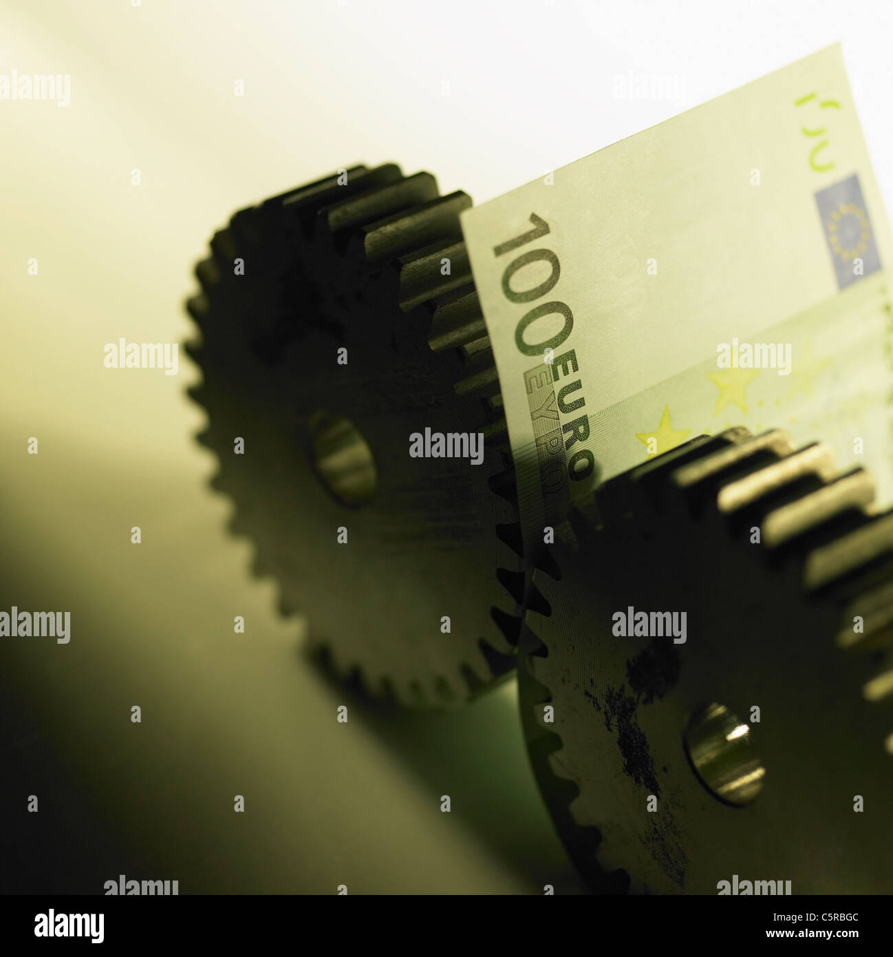 Paper money between saw-toothed wheel Stock Photo