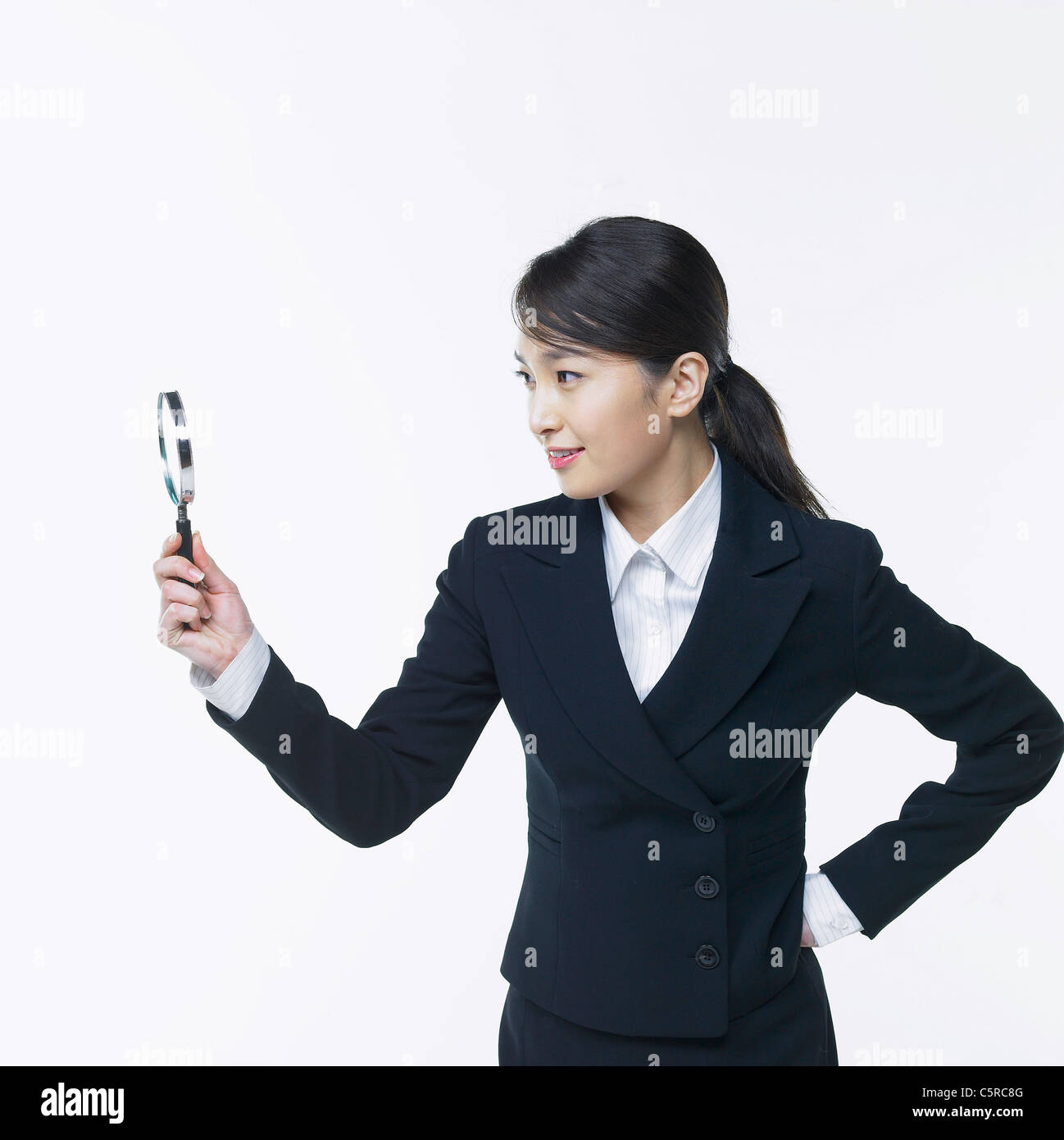 A woman looking at the magnifying glass Stock Photo - Alamy
