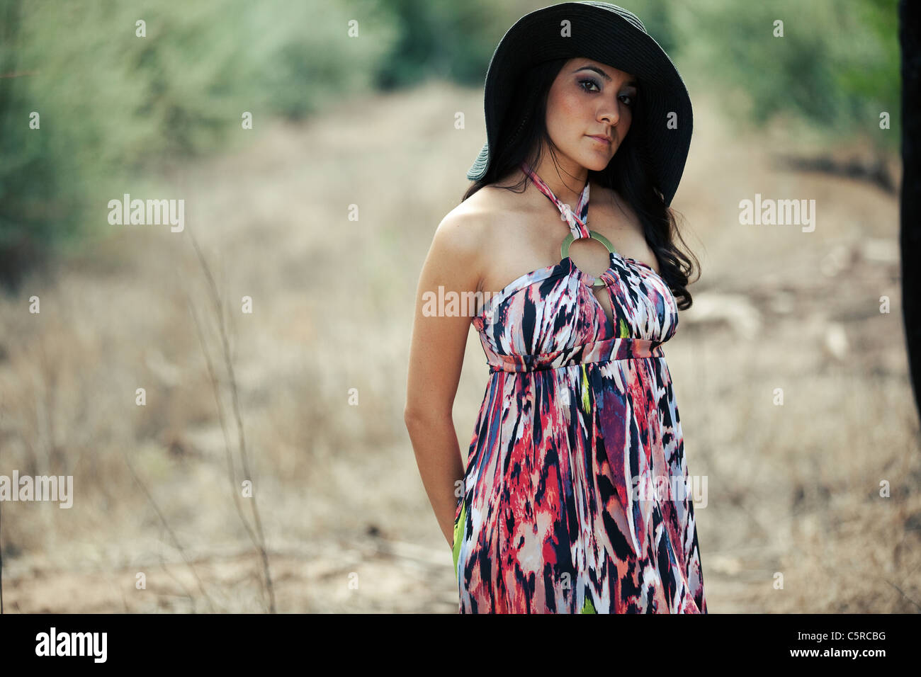 Serious young Hispanic woman wearing black hat outdoors Stock Photo