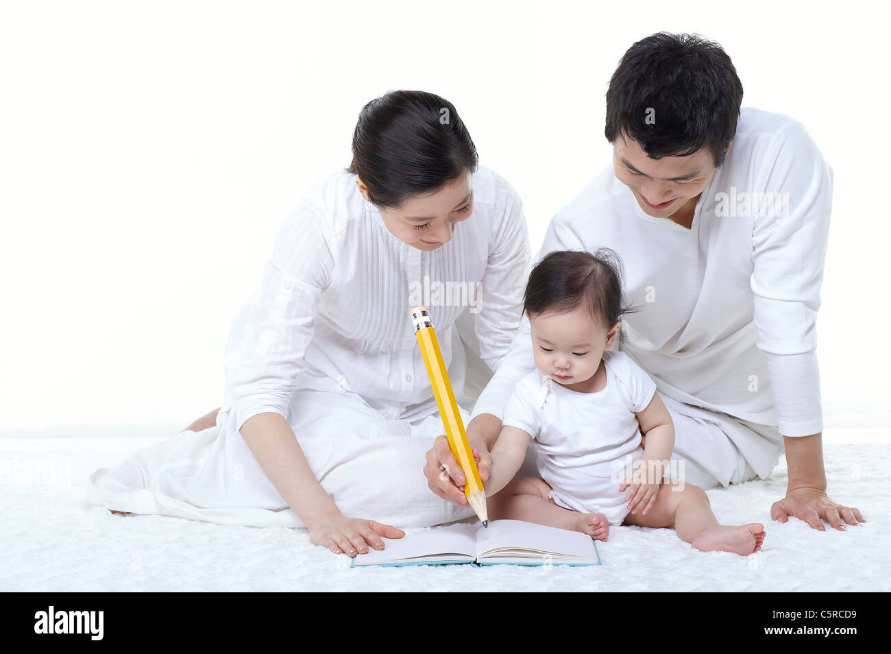 A baby studying with the parents Stock Photo - Alamy