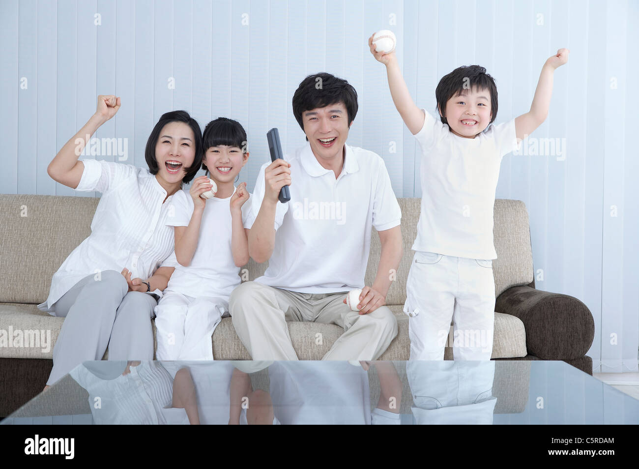 A family doing hurray in a living room Stock Photo