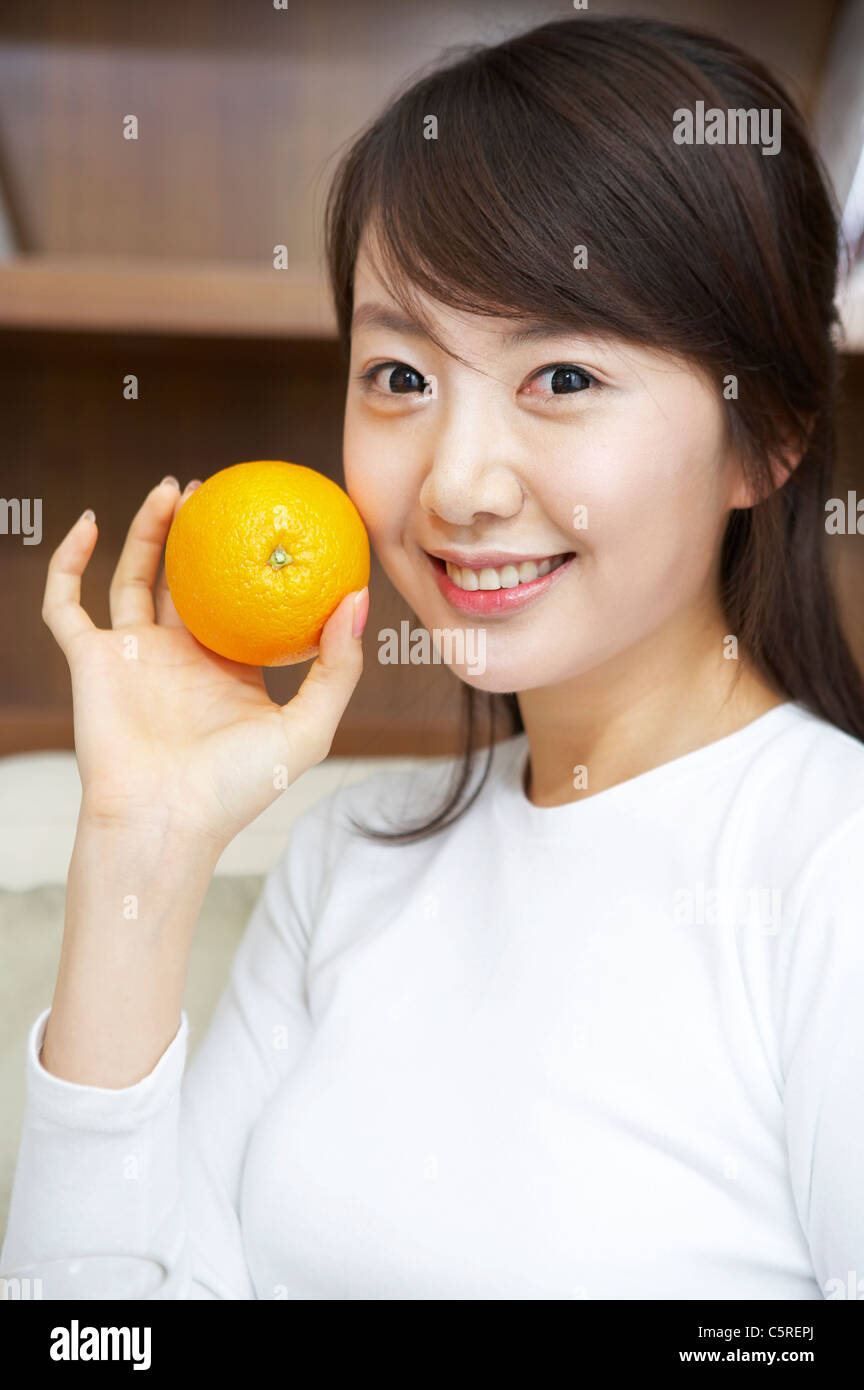 A woman holding an orange Stock Photo - Alamy