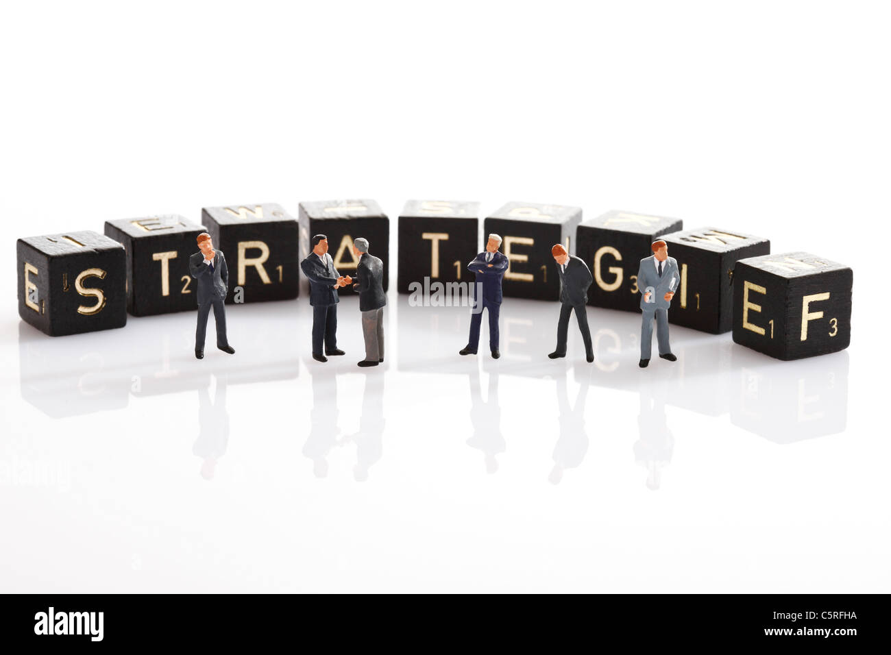 Scrabble tiles forming the single word strategy, in foreground Business men figurines Stock Photo