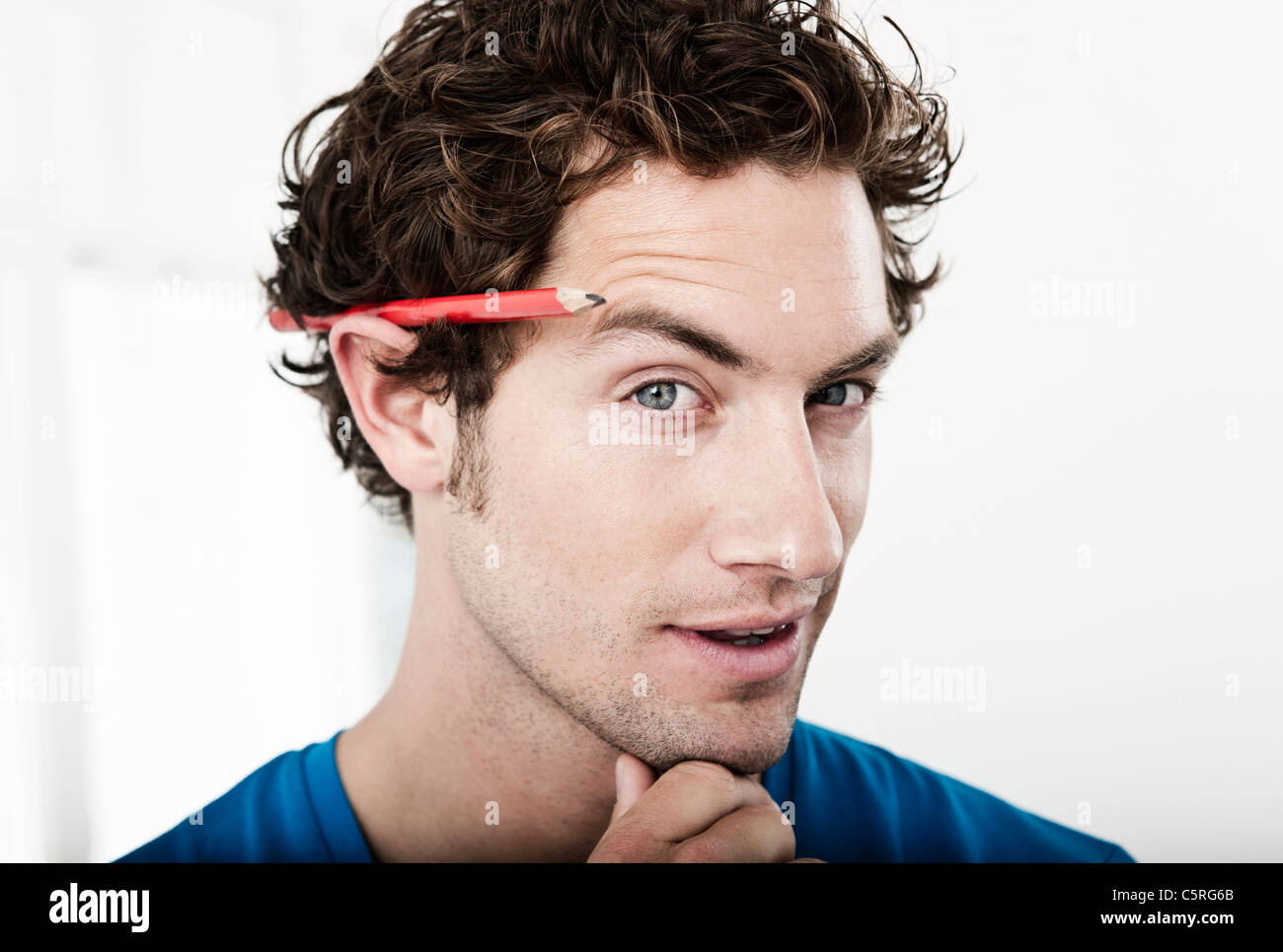 Germany, Cologne, Close up of young man with pencil behind ear in