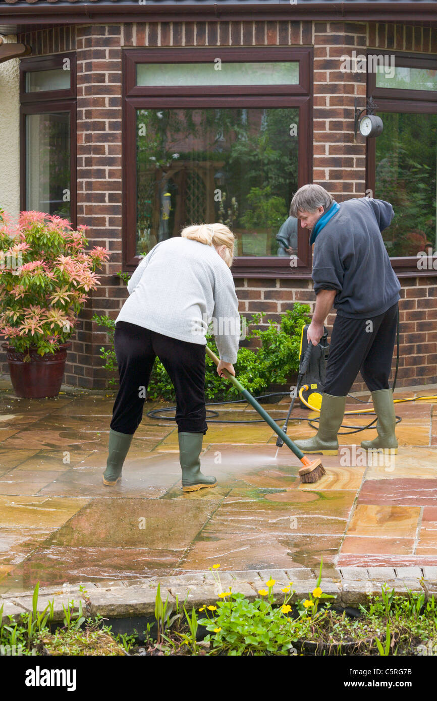 Couple jet washing a patio Stock Photo Alamy