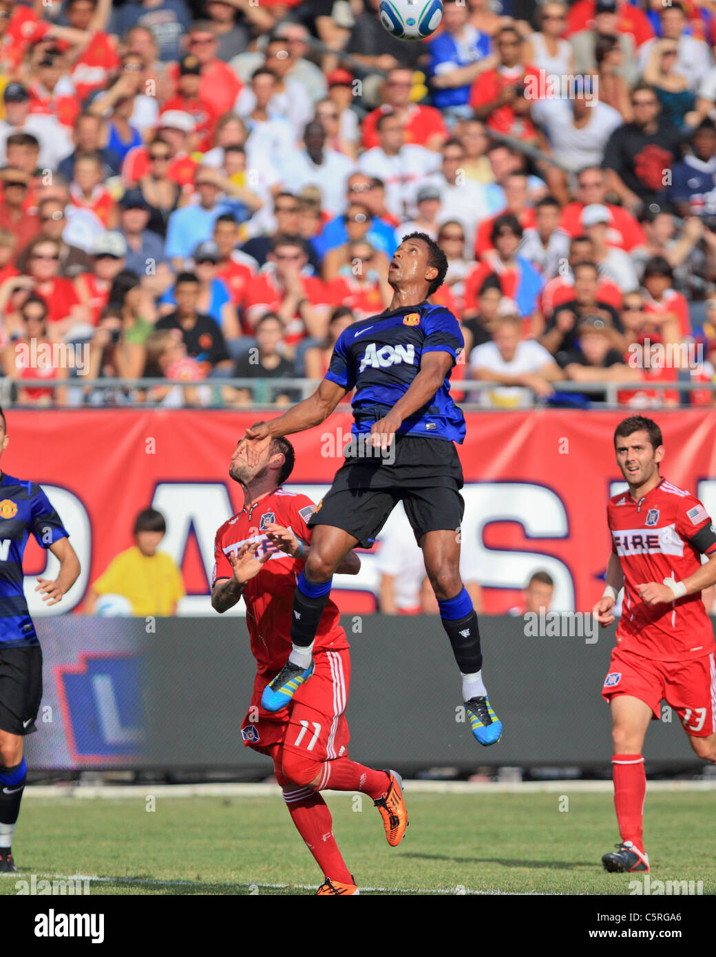 Manchester United wing, Luis Nani (C), rises high over Chicago defender Gonzalo Segares, to head the ball at Soldier Field. Stock Photo