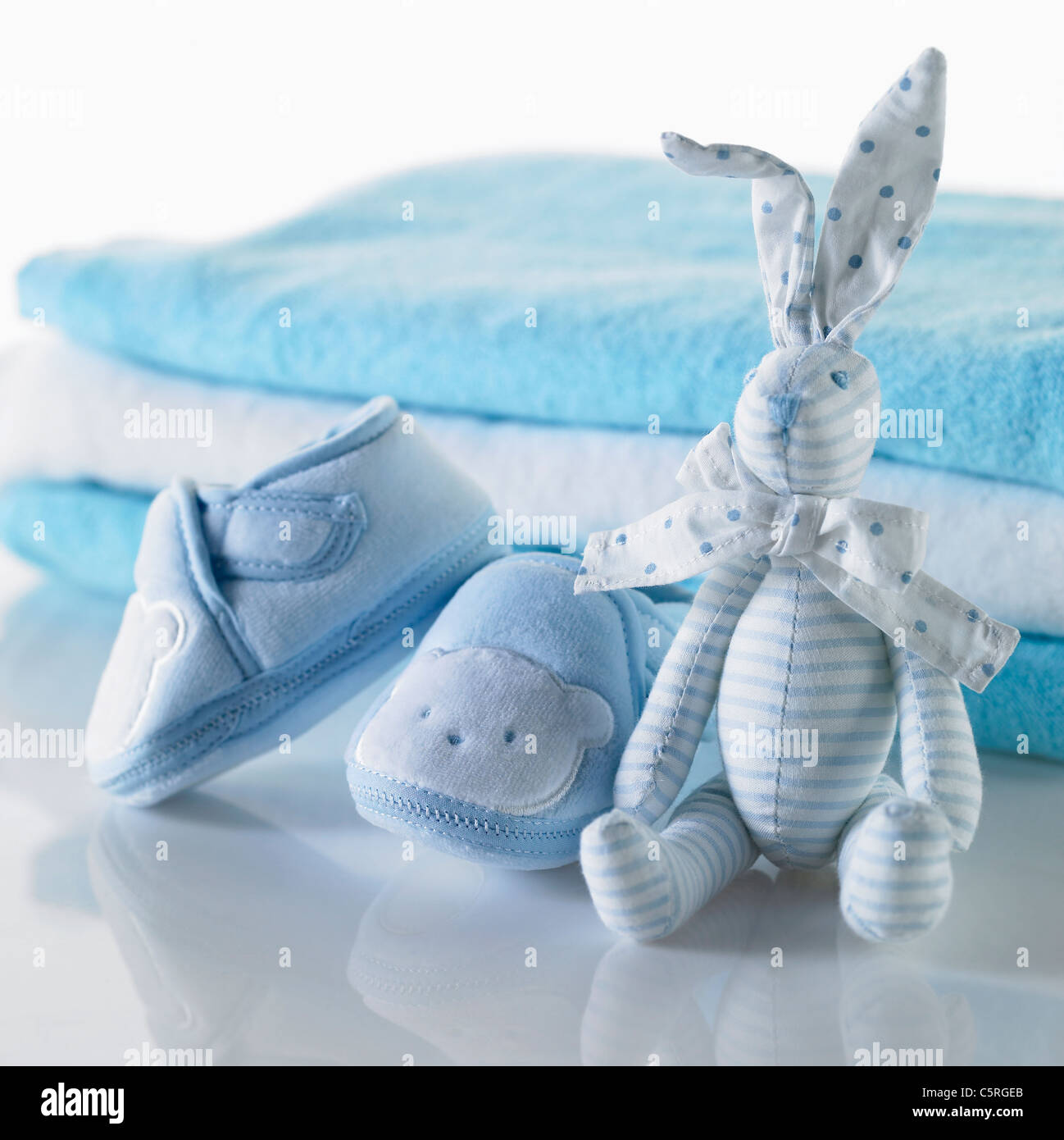 Baby's shoes and a doll Stock Photo - Alamy