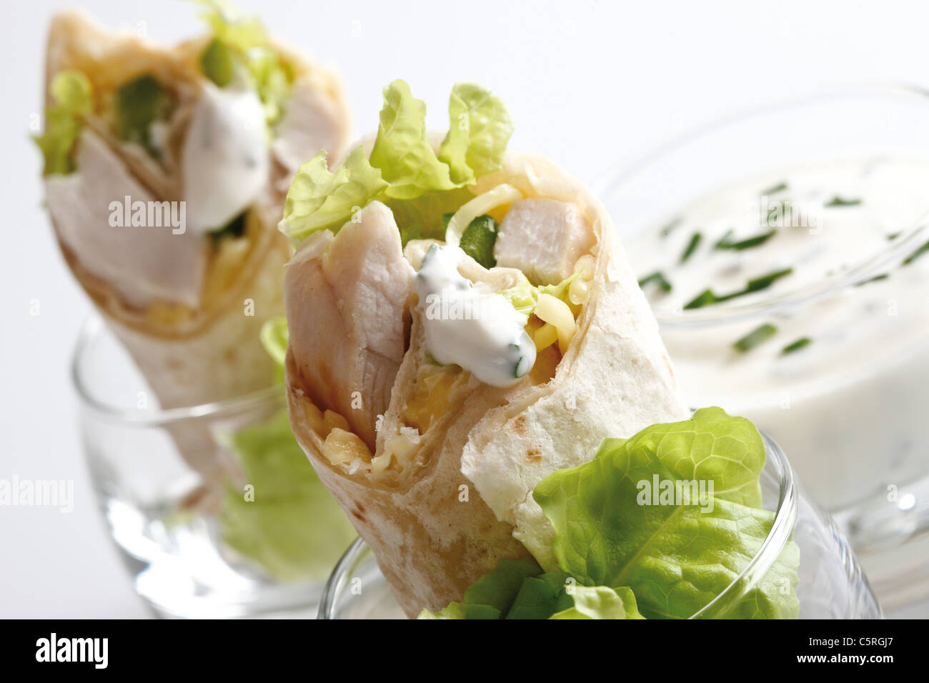 Chicken Wraps in glasses and Yoghurt dip in glass, closeup Stock Photo