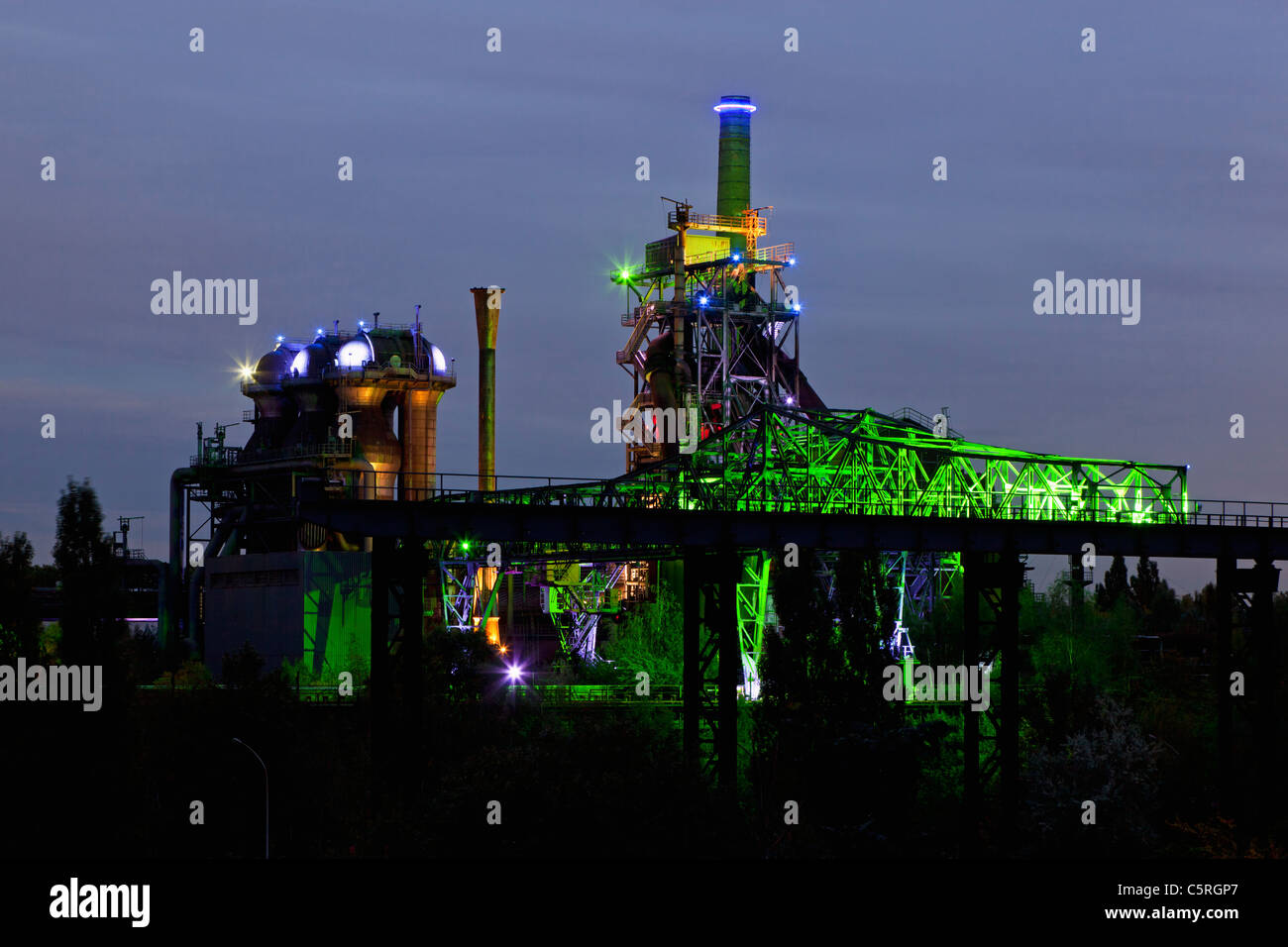 Germany Illuminated blast furnace and smoke stacks of old industrial plant Stock Photo
