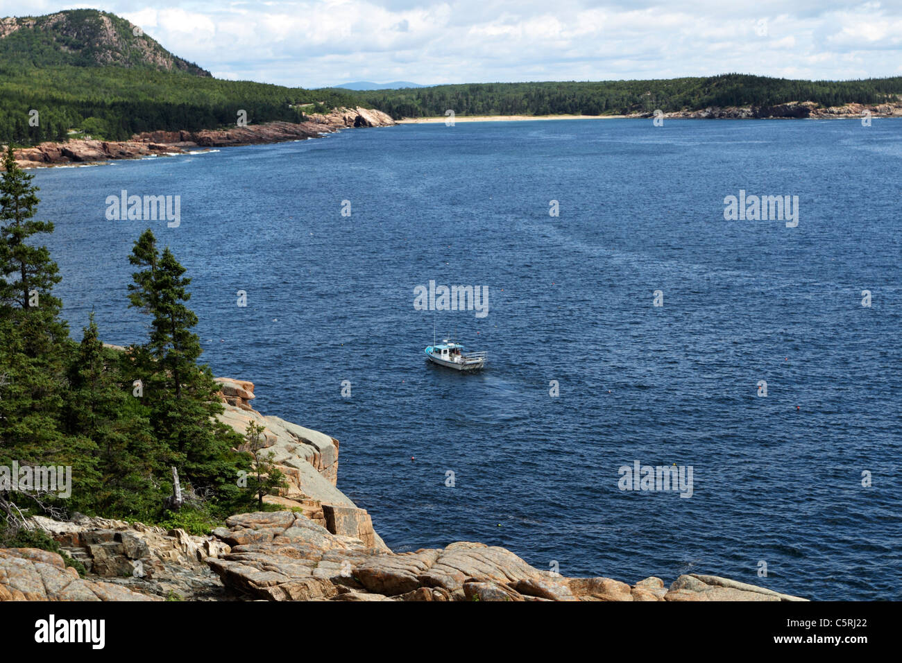 A lobster boat tending to its pots off the coast of Acadia National Park, Mount Desert Island, Maine, USA. Stock Photo