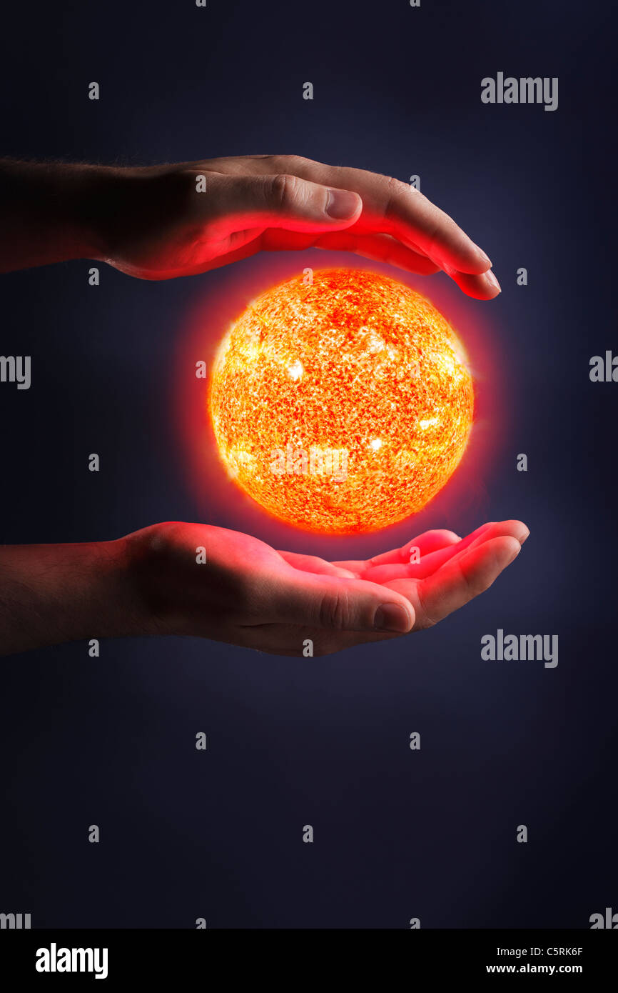 A Glowing sun between hands. Sun images provided by NASA. Stock Photo